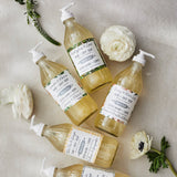 Collection de savons pour les mains et le corps Dot & Lil aux parfums floraux, présentés dans des flacons en verre à pompe