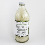 Bouteille en verre texturée contenant des sels de bain aux herbes, à l'eucalyptus et au citron vert