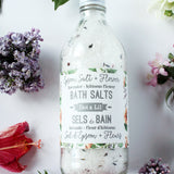 Flacons en verre texturés contenant des pétales de lavande et d'hibiscus pour le bain